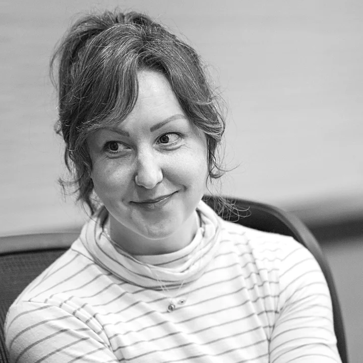 Amanda Burch smiling while listening in a group conversation